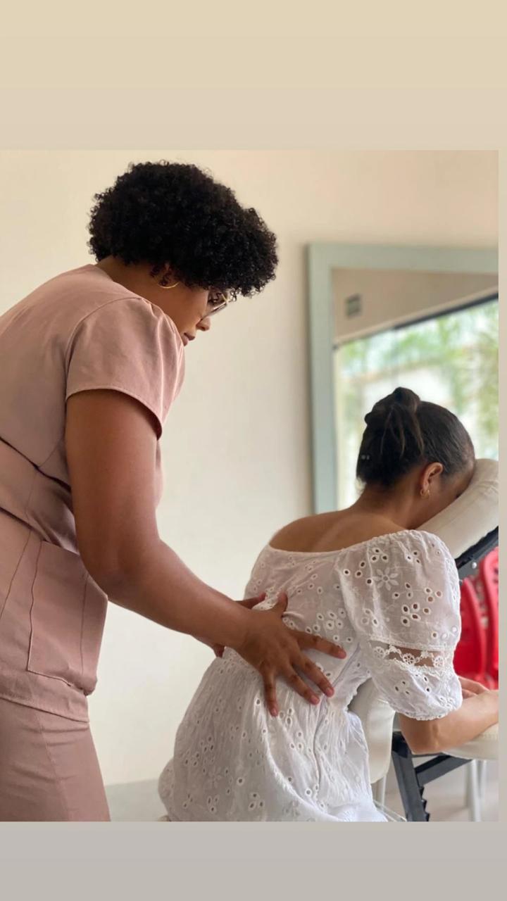 Gisele realizando quick massage em uma ação de bem-estar